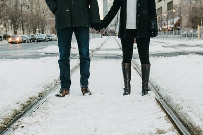 两人站在积雪覆盖的道路上的照片